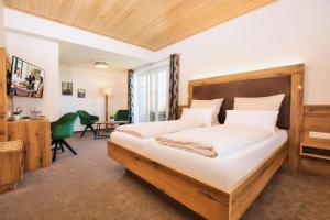 a bedroom with a large bed and a desk at Berghotel Mooshütte in Lohberg