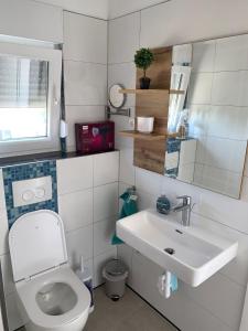 ein Badezimmer mit einem weißen WC und einem Waschbecken in der Unterkunft Appartement Vila Fajen in Sukošan