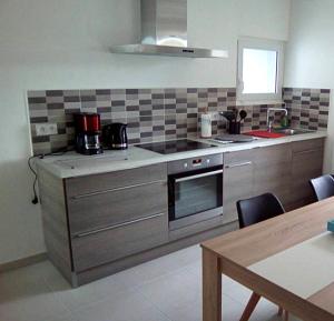 a kitchen with stainless steel appliances and a table at Maison de 2 chambres avec jardin amenage et wifi a Cast in Cast