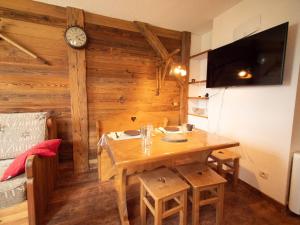 a dining room with a table and a clock on a wall at Appartement Valmorel, 1 pièce, 4 personnes - FR-1-291-710 in Valmorel