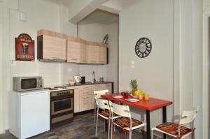 uma cozinha com uma mesa e cadeiras vermelhas, um fogão e micro-ondas em Stathmos Larissis A, a cozy 2BR Apartment, Clo... em Atenas