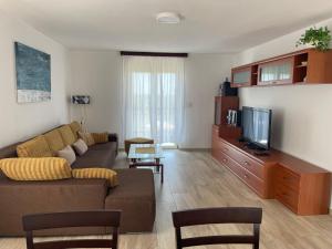 a living room with a couch and a tv at Apartment Rosello with private parking place 50m from the beach in Novigrad Istria