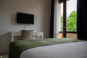 sypialnia z łóżkiem, biurkiem i oknem w obiekcie Casa Valcellina Hotel Ristorante w mieście Montereale Valcellina