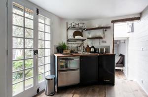 una cocina con electrodomésticos de acero inoxidable y negro en Appartement Gérard, tout équipé Paris 13éme, en París