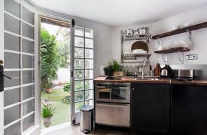 una cocina con fregadero y una puerta a un patio en Appartement Gérard, tout équipé Paris 13éme, en París