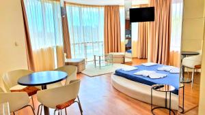 una habitación con una cama, una mesa y sillas en Favorit Aparthotel, en Sunny Beach