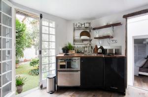 une cuisine équipée d'appareils en acier noir et inoxydable dans l'établissement Appartement Gérard, tout équipé Paris 13éme, à Paris