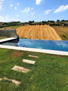 una piscina de agua frente a un campo en Casa Lunaria B&B en Porto SantʼElpidio