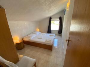 ein Schlafzimmer mit einem weißen Bett und einem Fenster in der Unterkunft Apartments Istra Nielsen in Premantura