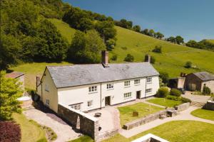 uma vista aérea de uma grande casa branca numa colina em Summergreen Farmhouse em Bampton