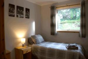a small bedroom with a bed and a window at Lovely 3 Bedroom Bungalow Located in Drummore in Drummore