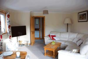 a living room with a white couch and a table at Lovely 3 Bedroom Bungalow Located in Drummore in Drummore