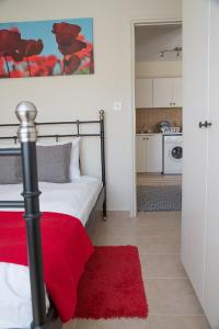 a bedroom with a bed with a red rug at Paphos Love Nest Apartment in Paphos City