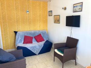 Habitación con 1 cama, 2 sillas y TV. en Appartement d'une chambre avec piscine partagee et jardin clos a Montmartin sur Mer a 2 km de la plage en Montmartin-sur-Mer
