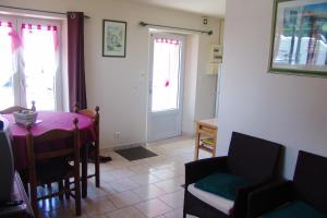 comedor con mesa, sillas y puerta en Appartement d'une chambre avec piscine partagee et jardin clos a Montmartin sur Mer a 2 km de la plage en Montmartin-sur-Mer