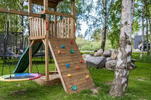 a wooden playset with a slide and a trampoline at VILLA AIDO in Palanga