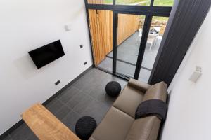 a living room with a couch and a flat screen tv at Romano Estate, The Courtyard in Penzance