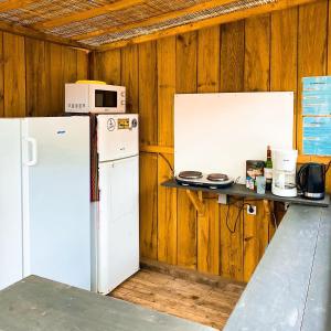 a kitchen with a refrigerator and a microwave on a counter at Hoya Surf Camp - Activités + logements in Biscarrosse