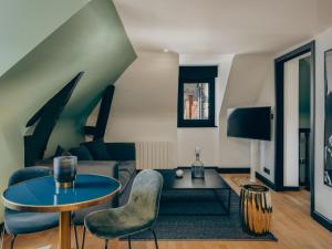 a living room with a table and chairs at Le Nemours Rennes in Rennes