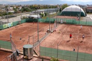 a group of people playing tennis on a tennis court at Hotel Pamira in Sibiu