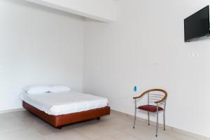 a bedroom with a bed and a chair and a tv at Preveza Rock Apartments in Chóïka