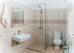 a bathroom with a toilet and a sink and a shower at Preveza Rock Apartments in Chóïka