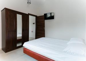 a bedroom with a white bed and a wooden cabinet at Preveza Rock Apartments in Chóïka