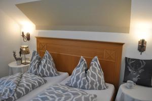 a bedroom with two beds with pillows and a headboard at Goldener Hahn Residence Ferienwohnungen mit Infrarot Sauna, Panorama Aussicht & Pool, Frühstücksservice im Aparthotel in Baiersbronn