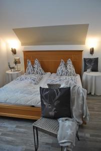 a bedroom with a bed with a chair and two tables at Goldener Hahn Residence in Baiersbronn