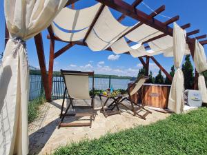 a patio with a table and chairs under a canopy at San na vodi in Smederevo