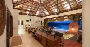 un grand salon avec une grande fenêtre et un salon où vous pourrez faire de l'exercice dans l'établissement 2071 - Villa Esquina del Cielo, à Santa Cruz Huatulco