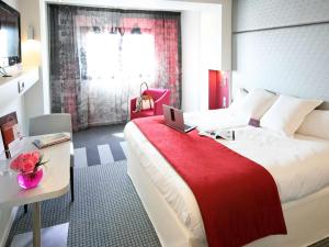 sypialnia z dużym łóżkiem z laptopem w obiekcie Mercure Paris Montmartre Sacré Coeur w Paryżu