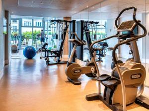 einen Fitnessraum mit Laufbändern und Trainingsgeräten in einem Gebäude in der Unterkunft Mercure Paris Montmartre Sacré Coeur in Paris