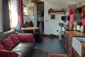 sala de estar con sofá y cocina en Peak District Cottage set in 5 acres near Buxton en Buxton