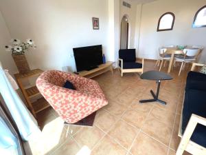 een woonkamer met een bank en een televisie bij Sea view apartment with garden Mojon Hills in Isla Plana