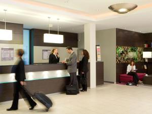 a group of people waiting at a counter in an airport at Mercure Hotel Düsseldorf Neuss in Neuss