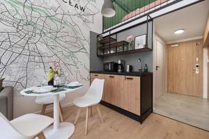 eine Küche mit einem Tisch und Stühlen im Zimmer in der Unterkunft Airport Studio Zarembowicza by Renters in Breslau