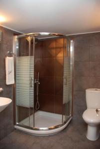 y baño con ducha, aseo y lavamanos. en il Palazzo Rooms & Suites, en Nauplia