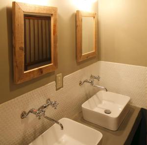 La salle de bains est pourvue d'un lavabo blanc et d'un miroir. dans l'établissement Tokyo Hikari Guesthouse, à Tokyo