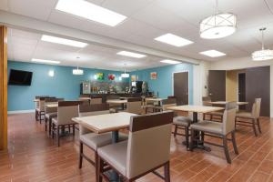 a dining room with tables and chairs and a bar at Quality Inn Magnolia in Magnolia