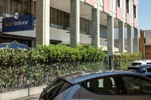 un coche aparcado en un aparcamiento frente a un edificio en Best Western Hotel Tritone, en Mestre