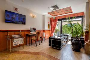 a living room with a desk and a table with a plant at Best Western Hotel Tritone in Mestre