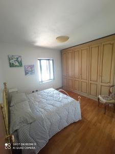 sypialnia z łóżkiem, oknem i krzesłem w obiekcie B&B Il glicine w mieście Antignano