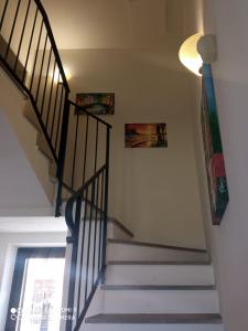 klatka schodowa z dwoma zdjęciami na ścianie i oknem w obiekcie B&B Il glicine w mieście Antignano