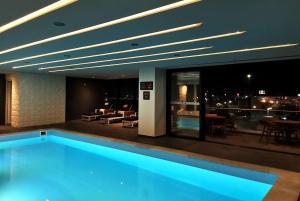 a swimming pool in a building with a view of the city at Ramada Encore by Wyndham Guadalajara Aeropuerto in Guadalajara