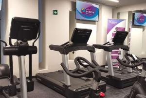 a gym with cardio machines and a tv at Ramada Encore by Wyndham Guadalajara Aeropuerto in Guadalajara