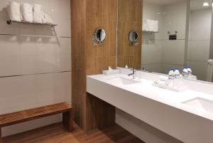 a bathroom with two sinks and a mirror at Ramada Encore by Wyndham Guadalajara Aeropuerto in Guadalajara