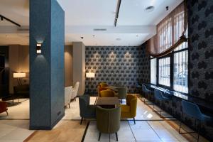 a lobby with a table and chairs and windows at Catalonia Plaza Catalunya in Barcelona