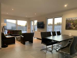 a living room with a dining room table and chairs at Ferienwohnung Bresser am Bernsteinsee in Sassenburg