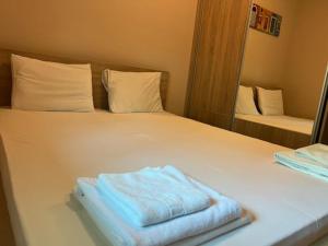 a white bed with two folded towels on it at The Old Town Terrace Apartments in Budva